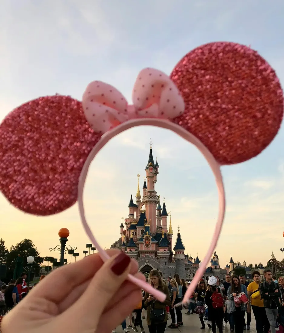 Oreilles de Minnie Mouse tenues devant le château de la Belle au Bois Dormant à Disneyland Paris
