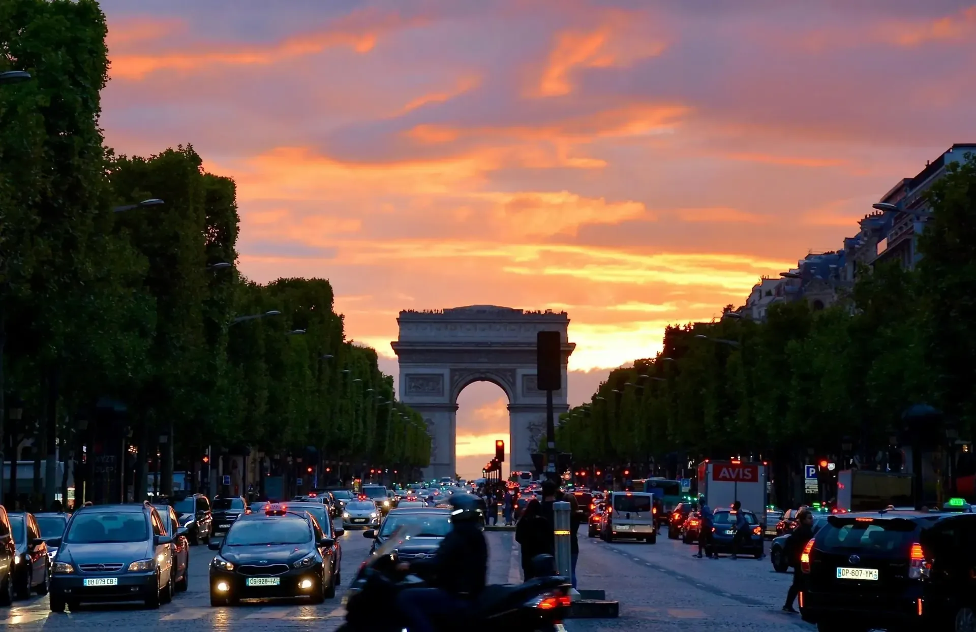 Arc de Triomphe au coucher de soleil avec circulation sur les Champs-Élysées à Paris